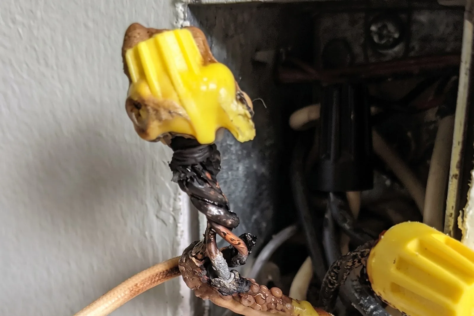 Melted twist-on wire connector and charred splice inside a wall box on aluminum branch wiring
