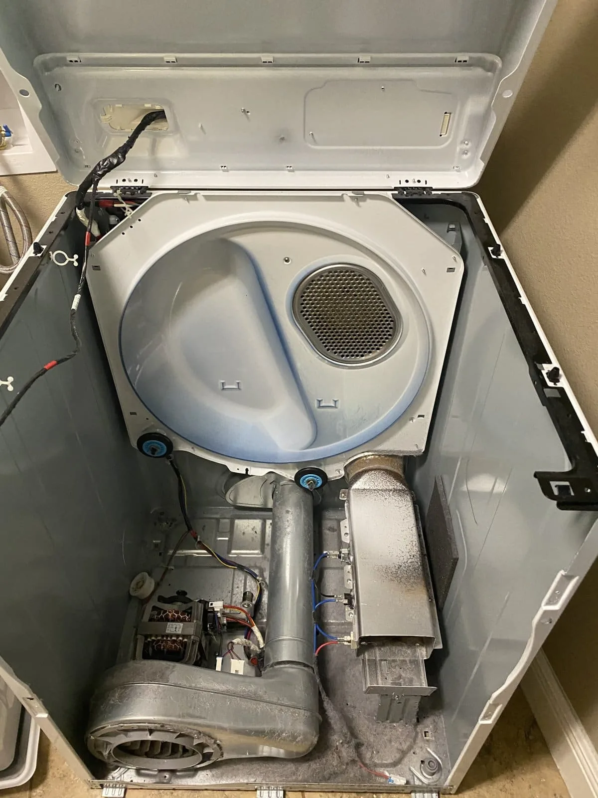 Dryer heating element duct and blower assembly exposed during repair — Tampa Bay