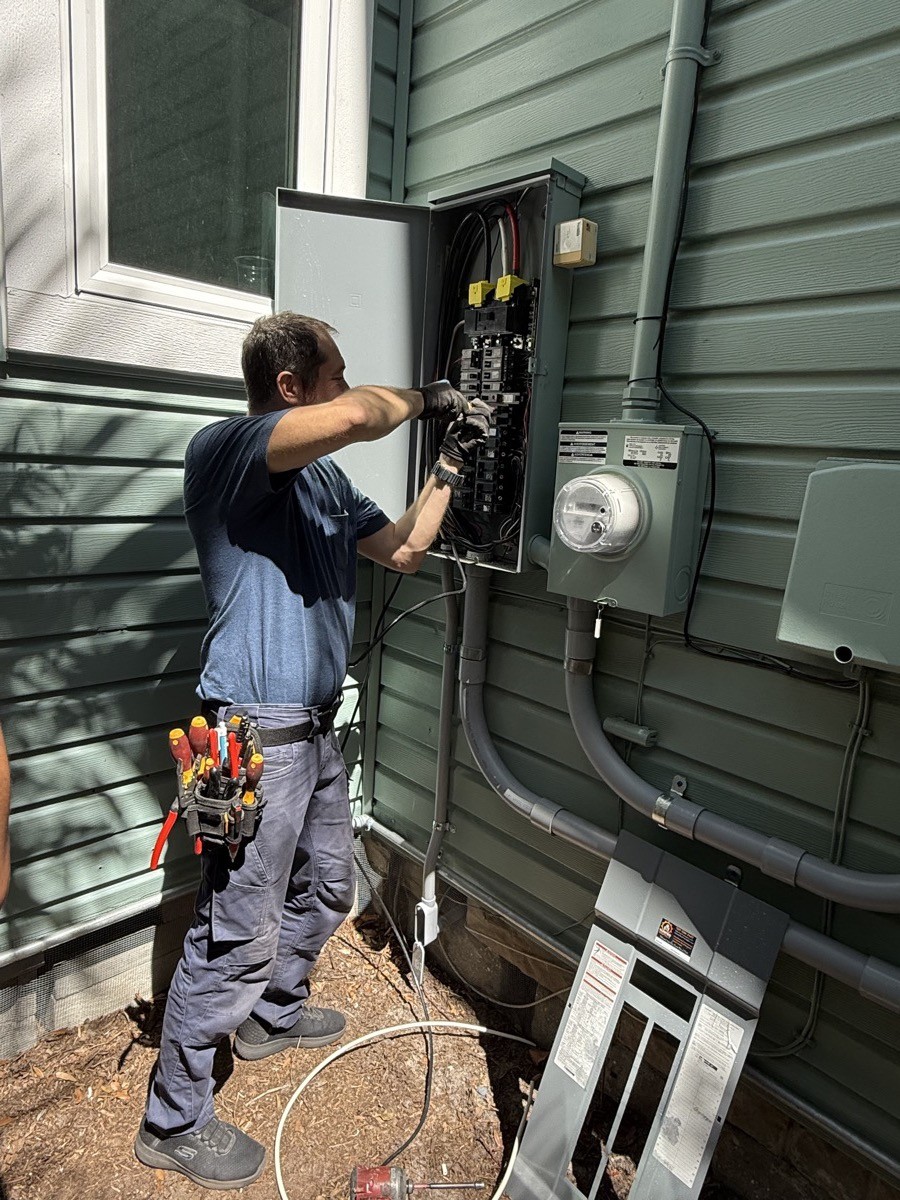 Electrician assessing the electrical panel for an EV charger install in Tampa Bay