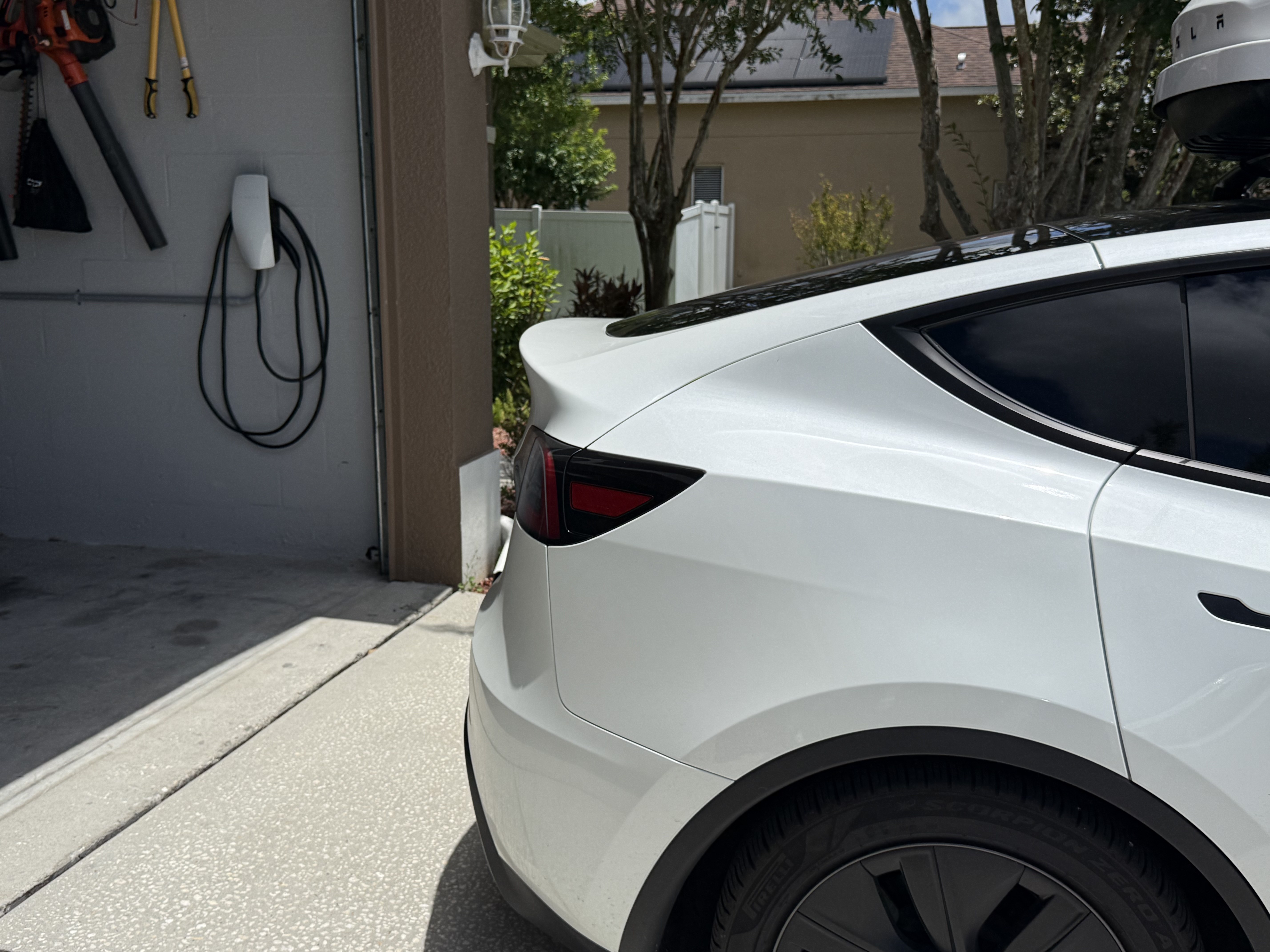 Tesla charging at a completed home EV charger installation in a Tampa Bay garage