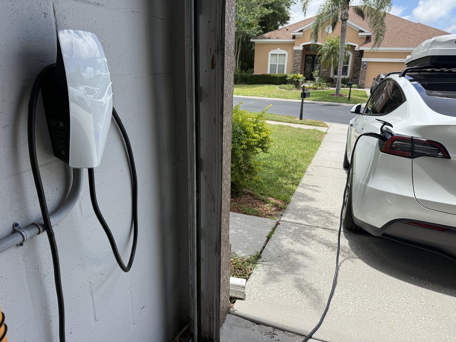 Installed Tesla Wall Connector charging a Tesla in a Tampa Bay driveway — Fixer Service EV charger installation