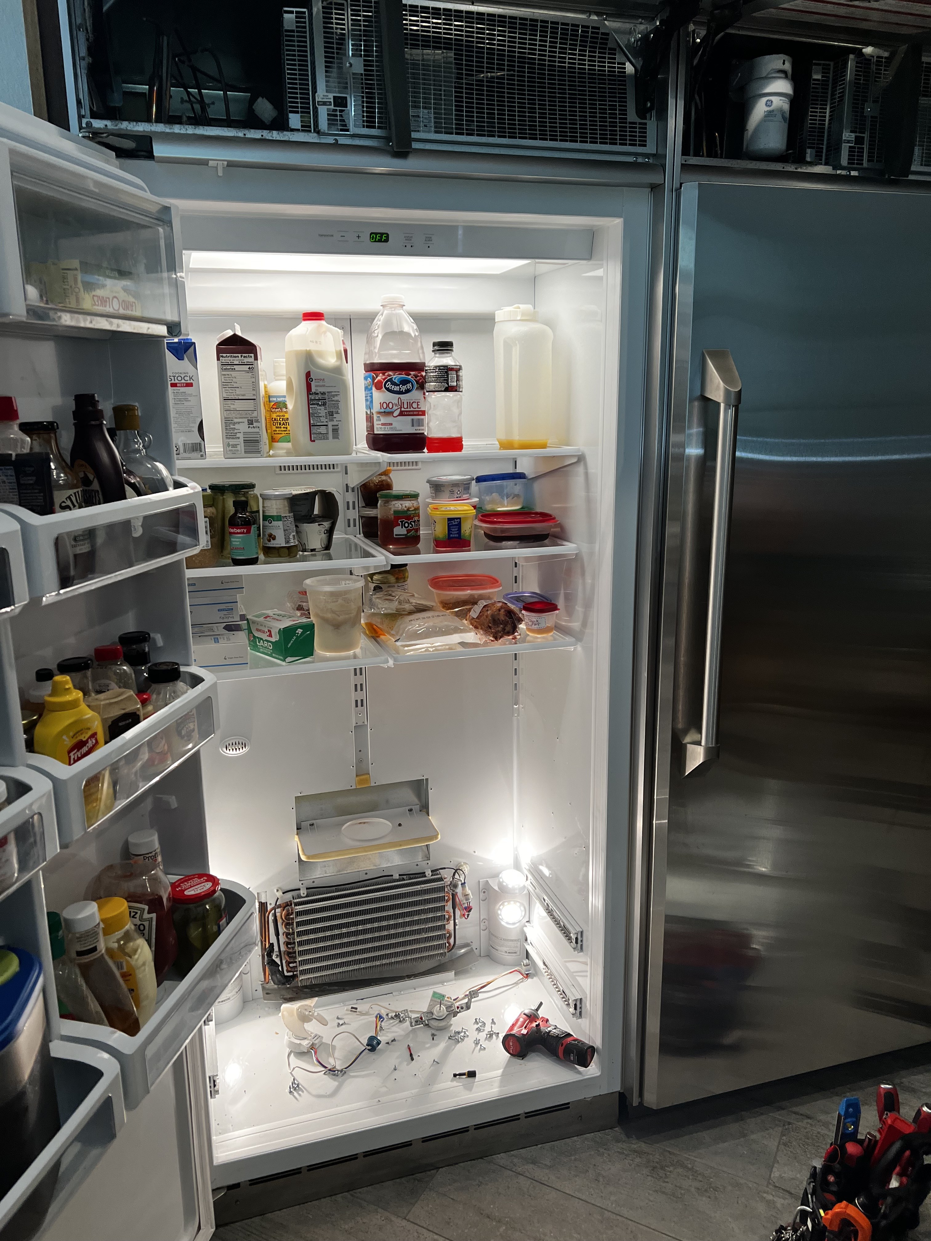 GE Monogram refrigerator interior diagnostic — evaporator coils and components exposed during service call in New Port Richey