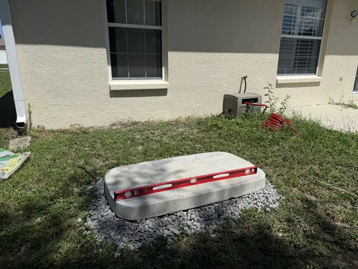Precast generator pad set on a leveled gravel bed in Tampa Bay