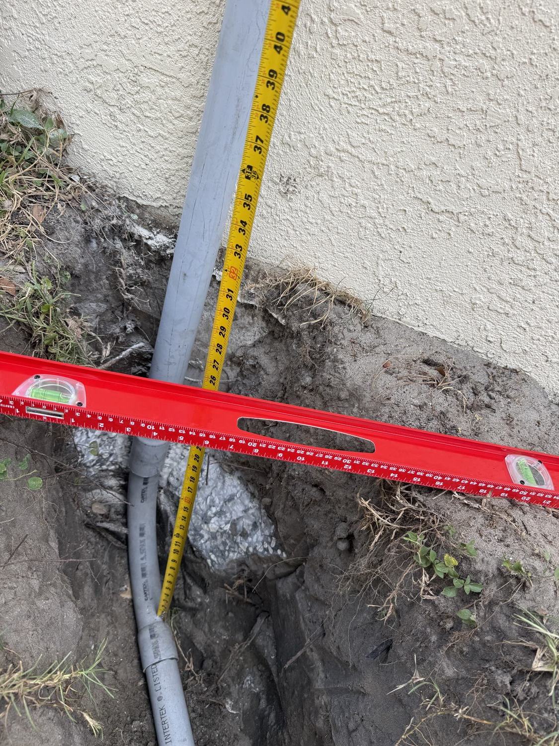 Gas line depth measured against a level at a Generac generator connection point in Tampa Bay