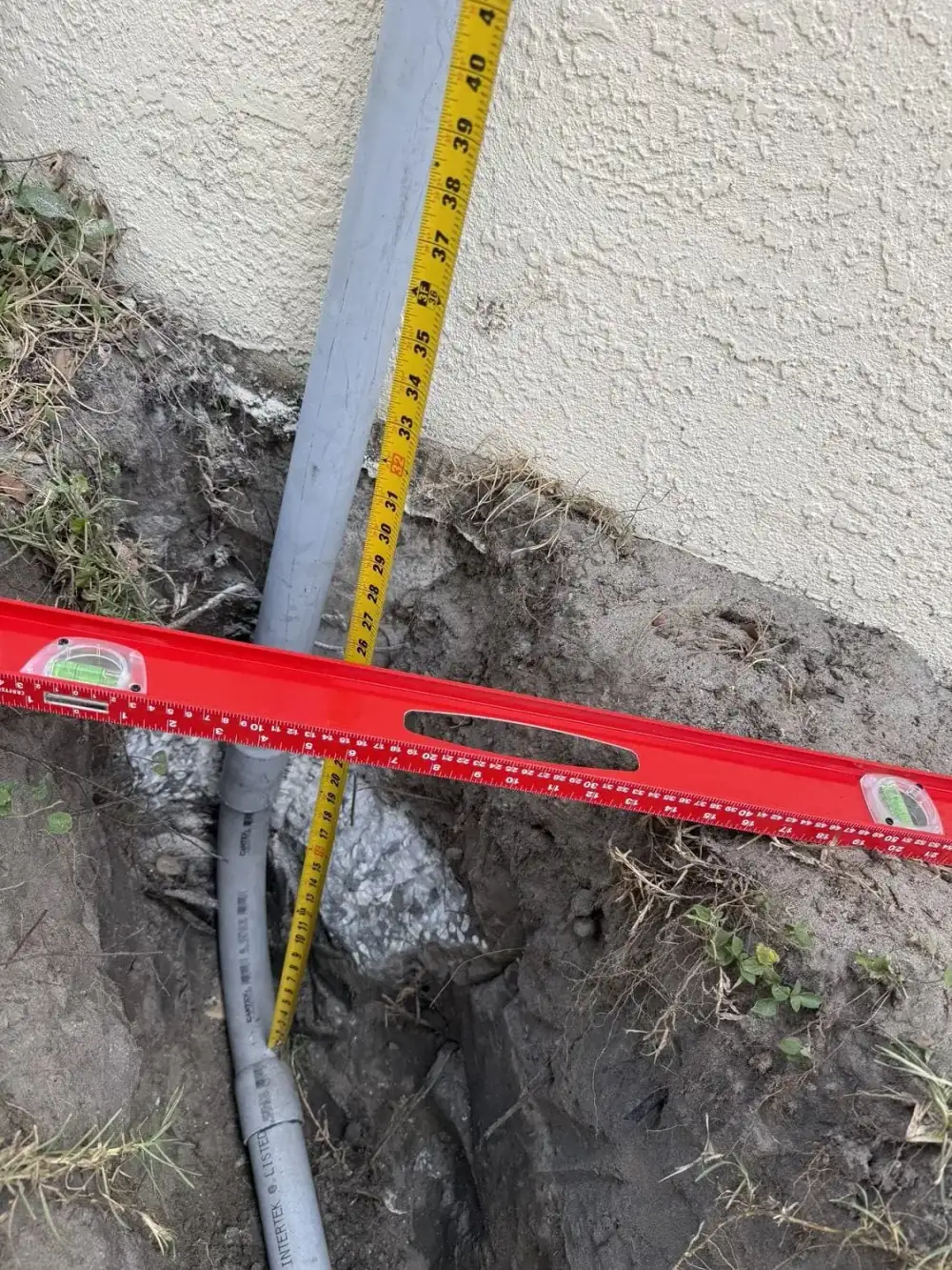 Gas line depth measured against a level at a Generac generator connection point in Tampa Bay