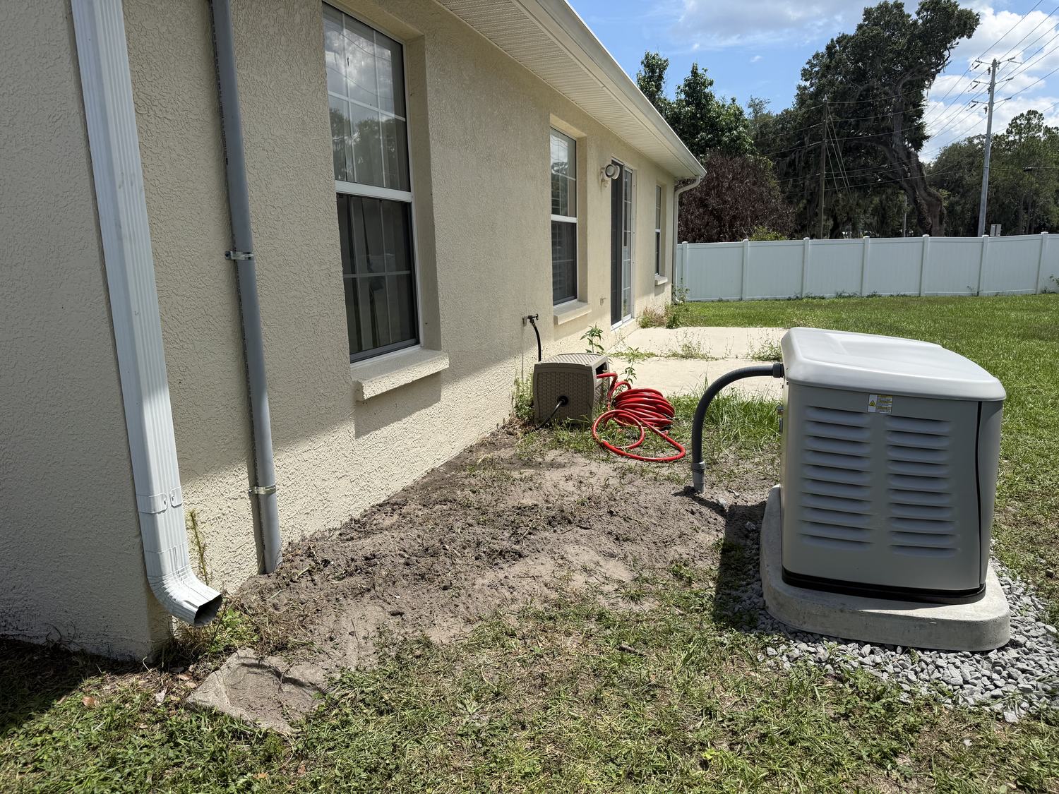 Completed Generac standby generator installation on its pad in a Tampa Bay backyard