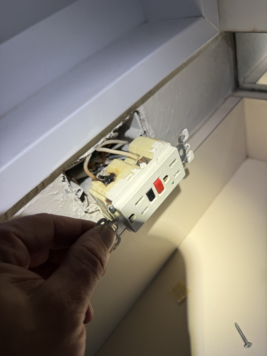 Failed GFCI outlet being removed during a Tampa Bay outlet repair