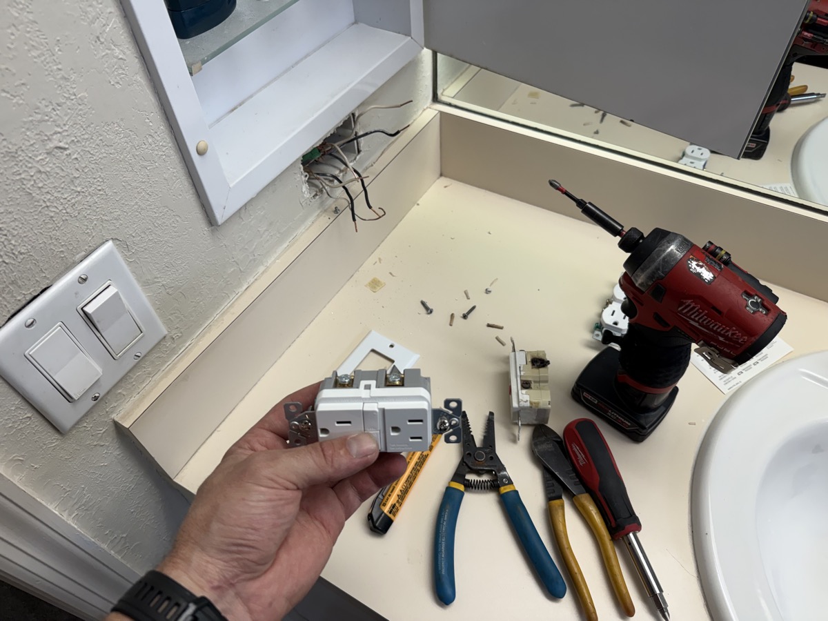GFCI outlet replacement with tools laid out in a Tampa Bay bathroom