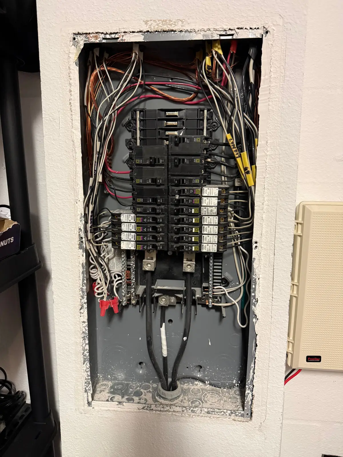 Open electrical panel in a Tampa Bay garage with the dead front removed, showing breakers and open spaces at the top for a new two-pole EV circuit