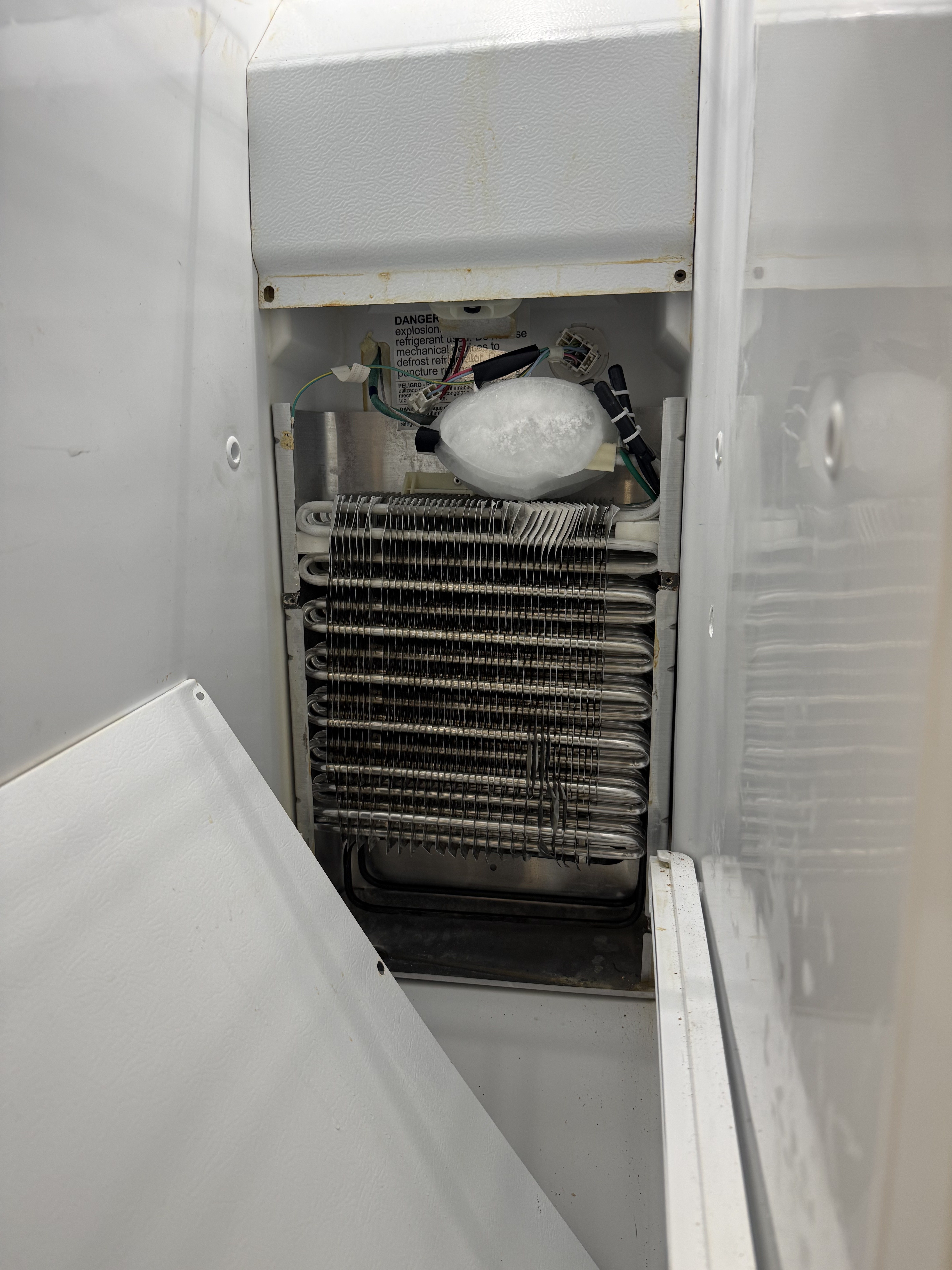 Refrigerator evaporator coils exposed during a Tampa Bay repair