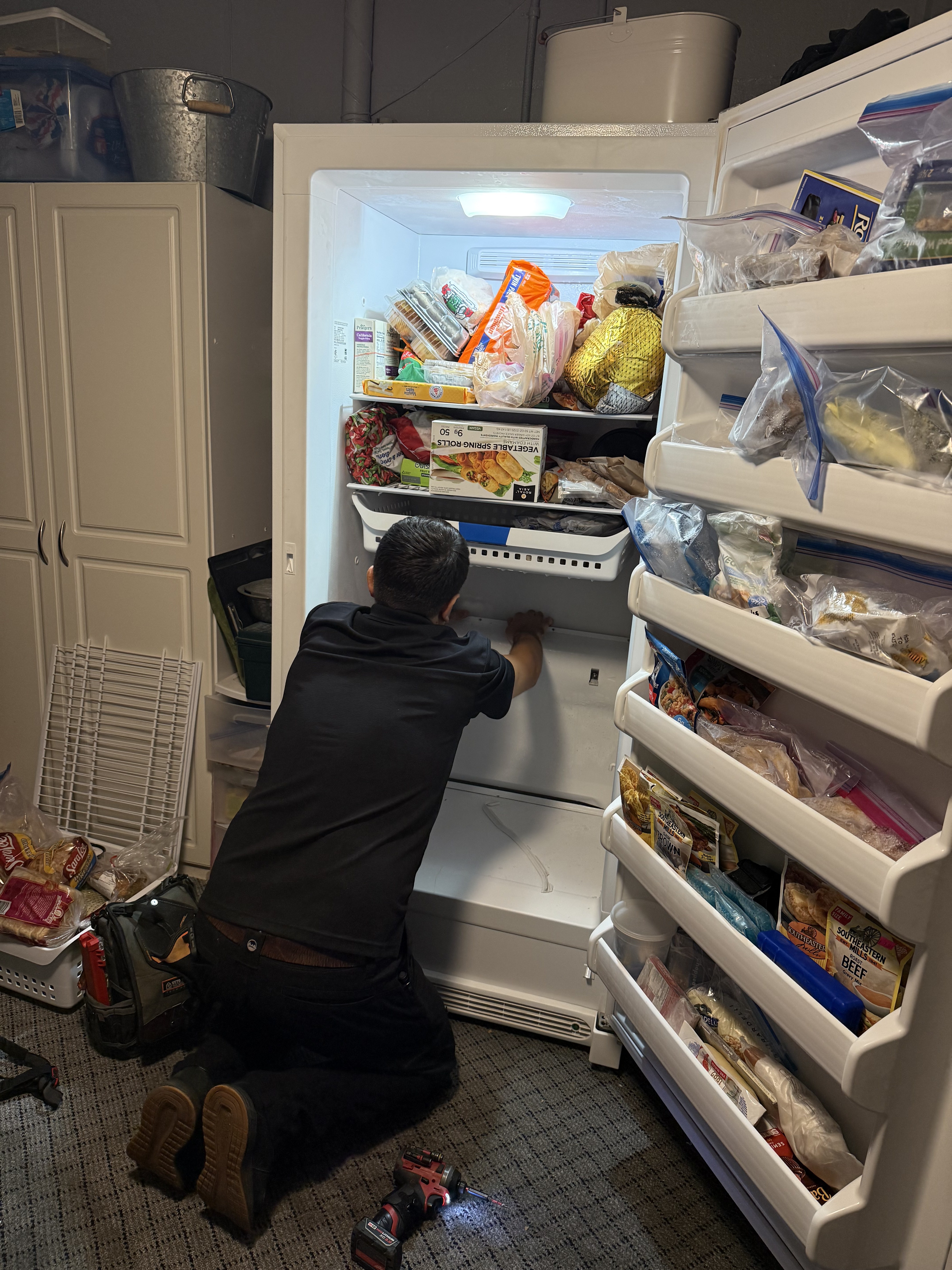 Fixer Service technician servicing a stand-up freezer during a diagnostic call — Tampa Bay