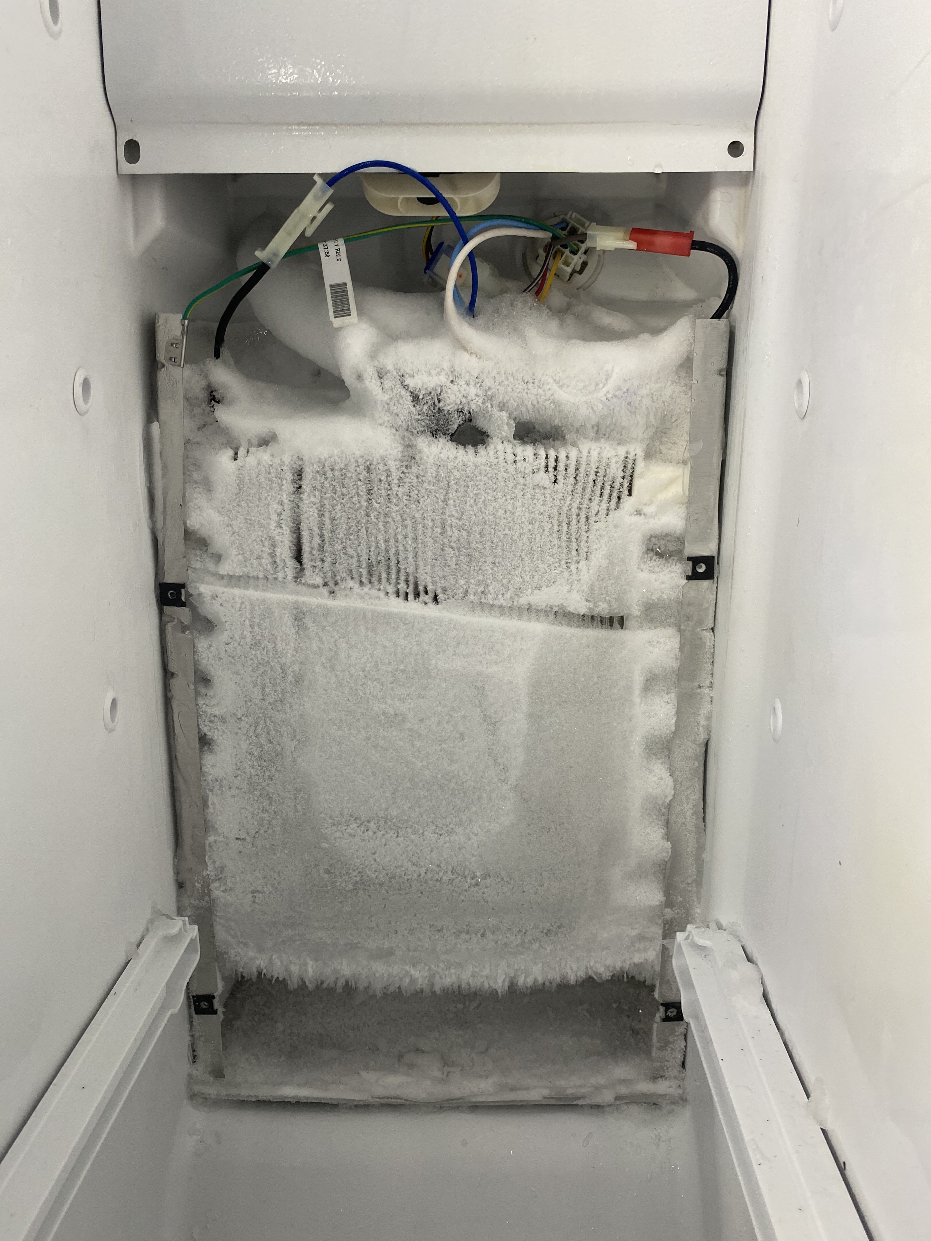 Heavy frost buildup on refrigerator evaporator coils from a failed defrost system — Tampa Bay