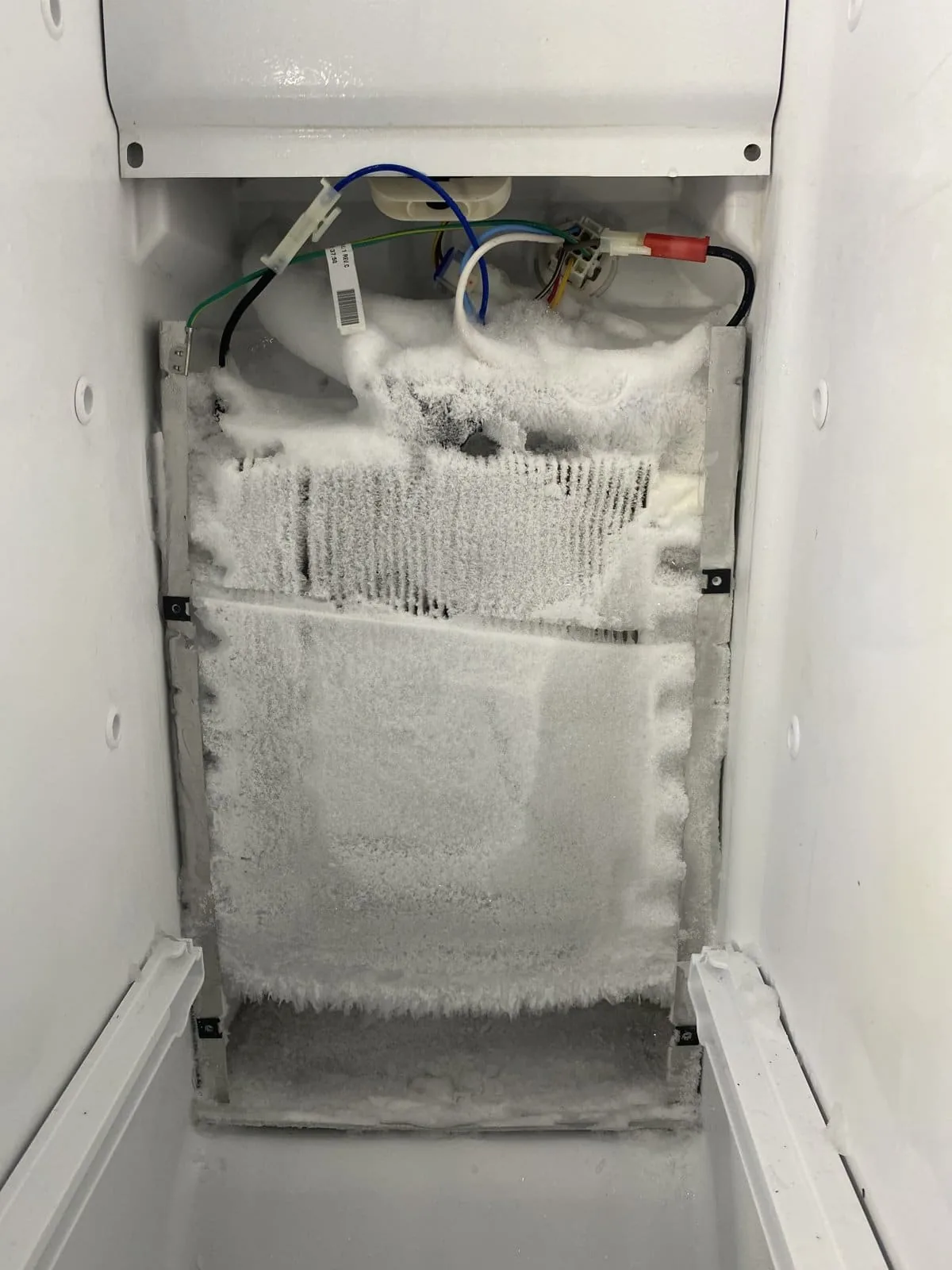 Heavy frost buildup on refrigerator evaporator coils from a failed defrost system — Tampa Bay