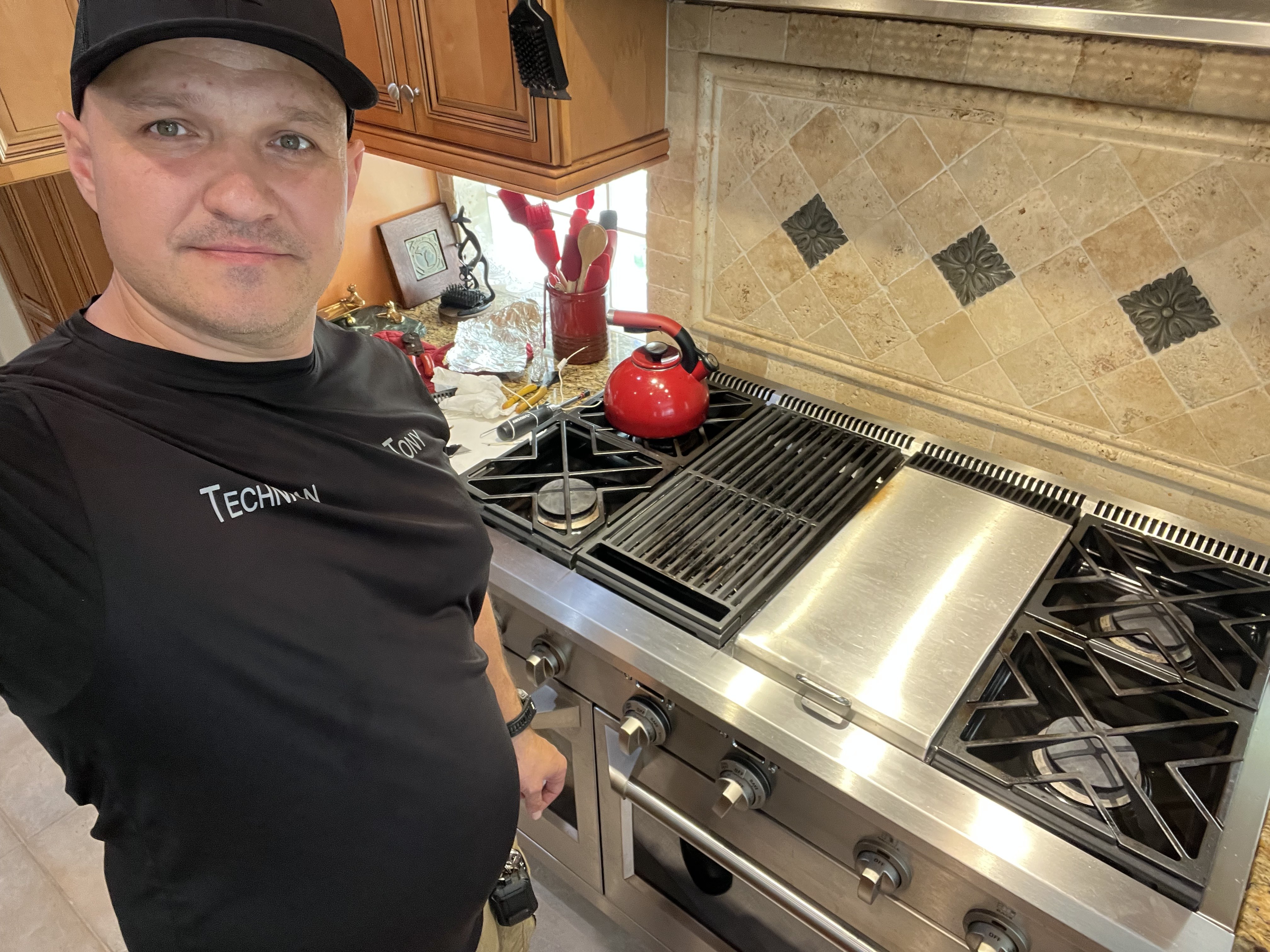 Fixer Service technician inspecting professional gas range in Tarpon Springs