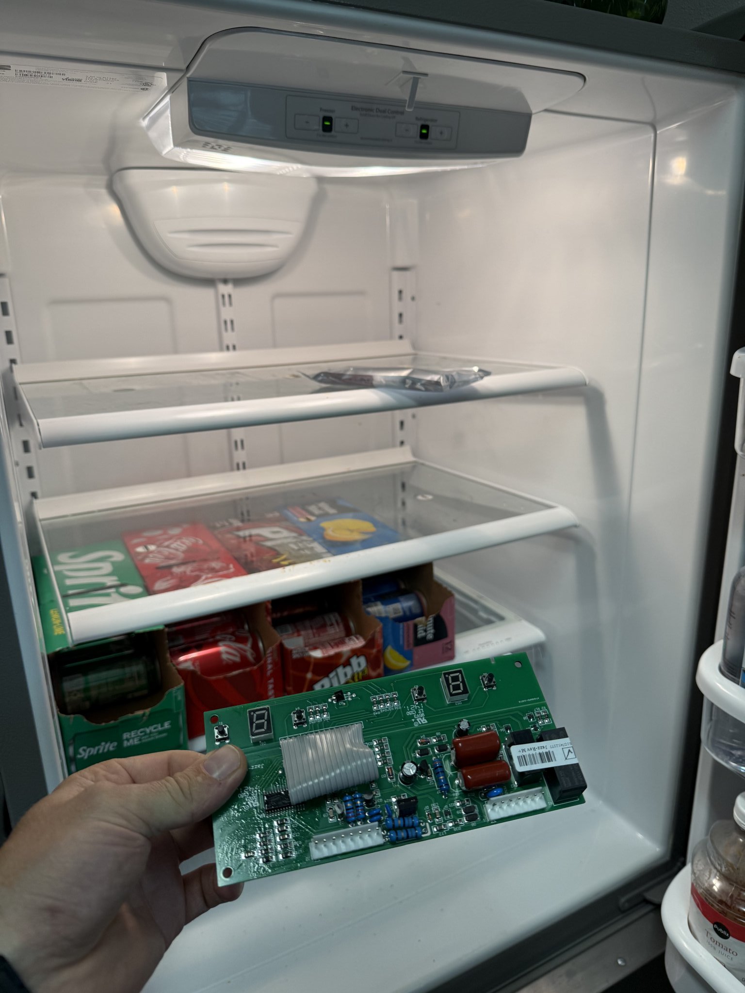 Fixer Service technician holding Whirlpool refrigerator control board during Palm Harbor repair